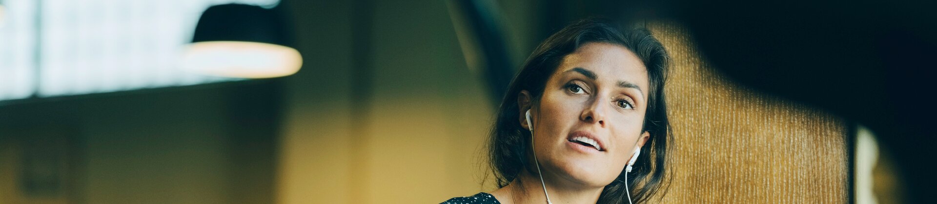 Opmærksom kvinde med en telefon og en kaffekop