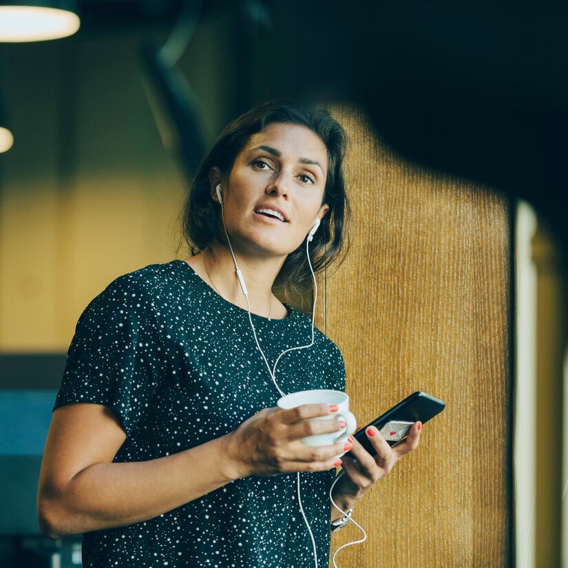 Kvinde med telefon og kaffekop